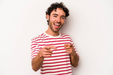 Beyaz arka planda izole edilmiş genç beyaz adam parmaklarıyla ön tarafı işaret ediyor..