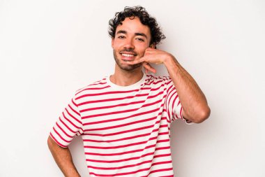 Beyaz arka planda izole edilmiş genç beyaz bir adam parmakları olan bir cep telefonu hareketi gösteriyor..