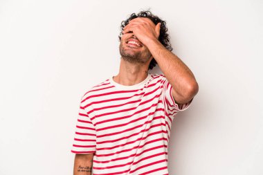 Beyaz arka planda izole olmuş genç beyaz bir adam ellerini başının üstünde tutarak neşeyle gülüyor. Mutluluk kavramı.