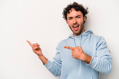 Beyaz arka planda izole edilmiş genç beyaz bir adam işaret parmağıyla fotokopi alanını işaret ederek heyecan ve arzusunu ifade ediyor..