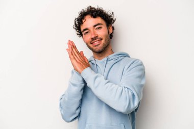 Beyaz arka planda izole olmuş genç beyaz bir adam enerjik ve rahat hissediyor, ellerini ovuşturuyor..