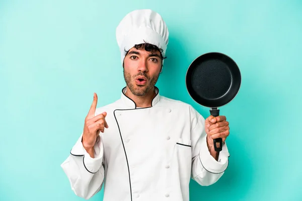 年轻的高加索厨师拿着被蓝色背景隔离的飞盘 有一些伟大的想法 创意的概念 — 图库照片