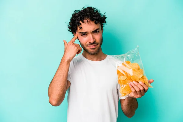 Young Caucasian Man Holding Bag Chips Isolated Blue Background Showing — Stockfoto