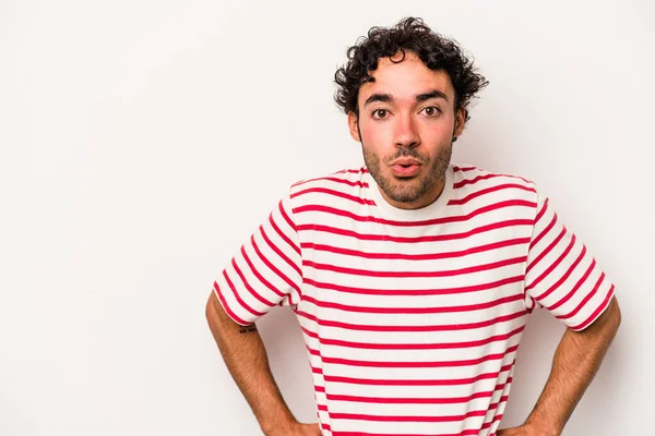 Beyaz arka planda izole edilmiş genç beyaz adam gördüğü bir şey yüzünden şoka uğruyor..