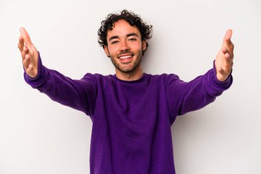 Beyaz arka planda izole olmuş genç beyaz bir adam zaferi veya başarıyı kutluyor, şaşırıyor ve şok oluyor..