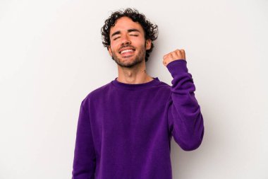 Beyaz arka planda izole edilmiş genç beyaz bir adam zaferi, tutkuyu ve coşkuyu kutluyor, mutlu bir ifade..