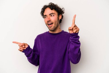 Beyaz arka planda izole edilmiş genç beyaz bir adam farklı kopya alanlarını gösteriyor, birini seçiyor, parmaklarıyla gösteriyor..