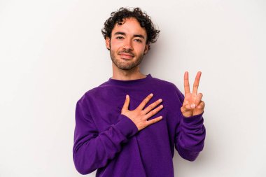 Beyaz arka planda izole edilmiş genç beyaz adam yemin ediyor, elini göğsüne koyuyor..