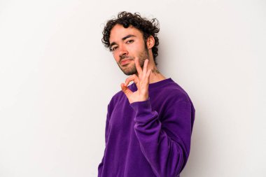 Beyaz arka planda izole edilmiş genç beyaz bir adam bir göz kırptı ve elleriyle iyi bir jest yaptı..