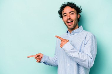 Beyaz arka planda izole edilmiş genç beyaz bir adam işaret parmağıyla fotokopi alanını işaret ederek heyecan ve arzusunu ifade ediyor..