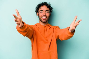 Beyaz arka planda izole edilmiş genç beyaz adam kameraya sarıldığı için kendinden emin hissediyor..