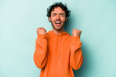 Beyaz arka planda izole edilmiş genç beyaz adam tasasız ve heyecanlı bir şekilde tezahürat yapıyor. Zafer konsepti.