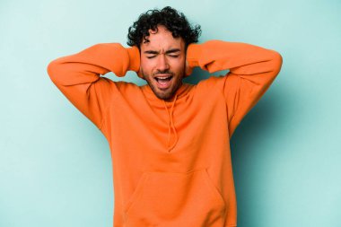 Beyaz arka planda izole edilmiş genç beyaz bir adam kulakları kulaklarıyla kapatıyor ve çok ses duymamaya çalışıyor..