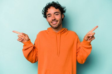 Beyaz arka planda izole edilmiş genç beyaz bir adam farklı kopya alanlarını gösteriyor, birini seçiyor, parmaklarıyla gösteriyor..