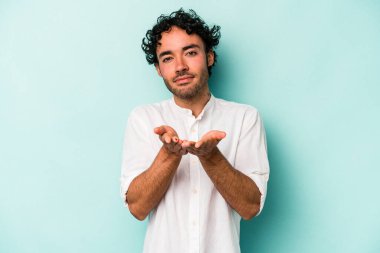 Beyaz arka planda izole edilmiş genç beyaz bir adam elinde avuç içi bir şeyle kameraya sunuyor..