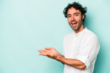 Beyaz arka planda izole edilmiş beyaz tenli genç bir adam palmiyesinde bir kopya alanı tutuyor..