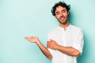 Beyaz arka planda izole edilmiş genç beyaz bir adam bir palmiye üzerinde fotokopi alanı gösteriyor ve belinde başka bir el tutuyor..