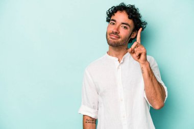 Beyaz arka planda izole edilmiş beyaz tenli genç bir adam bir numarayı parmağıyla gösteriyor..