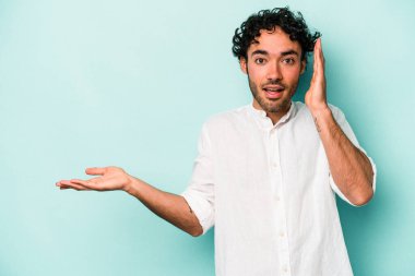 Beyaz arka planda izole edilmiş genç beyaz bir adam bir avuç içinde fotokopi alanı tutuyor, el üstünde tutuyor. Şaşırmış ve mutlu..