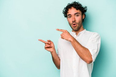 Beyaz arka planda izole edilmiş genç beyaz bir adam işaret parmağıyla fotokopi alanını işaret ederek heyecan ve arzusunu ifade ediyor..