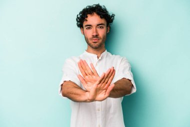 Beyaz arka planda izole edilmiş genç beyaz bir adam elini uzatmış, dur işareti göstererek seni engelliyor..