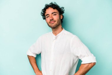 Beyaz arka planda izole edilmiş, hoşnutsuzca kaşlarını çatmış, kollarını kavuşturmuş genç beyaz bir adam..