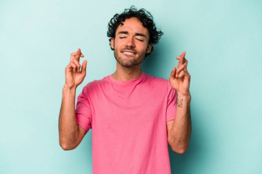 Beyaz arka planda izole genç beyaz adam şans dilemek için şans diliyor.