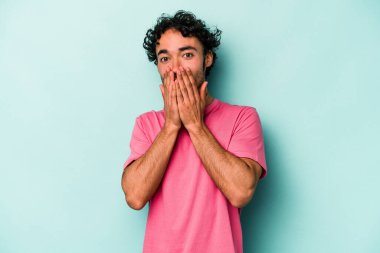 Beyaz arka planda izole edilmiş genç beyaz adam elleriyle ağzını kapatırken şok oldu..