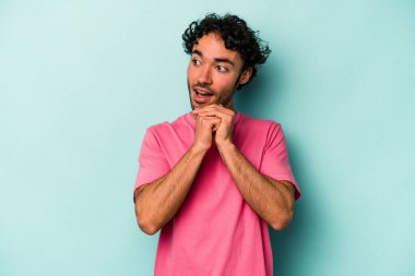 Beyaz arka planda izole genç beyaz adam ellerini çenesinin altında tutuyor, mutlu bir şekilde yana bakıyor..