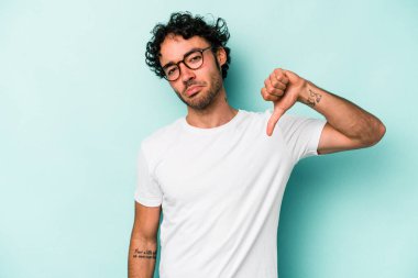 Beyaz arka planda izole edilmiş genç beyaz adam baş parmağını aşağı gösteriyor, hayal kırıklığı konsepti..