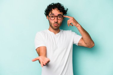 Beyaz arka planda izole edilmiş genç beyaz bir adam elinde bir ürün tutuyor ve.