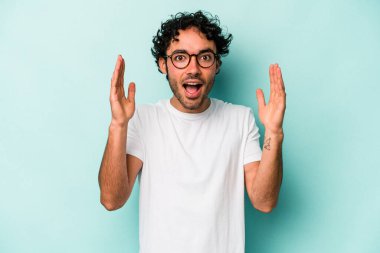 Beyaz arka planda izole genç beyaz adam hoş bir sürpriz alıyor, heyecanlı ve el kaldırıyor..