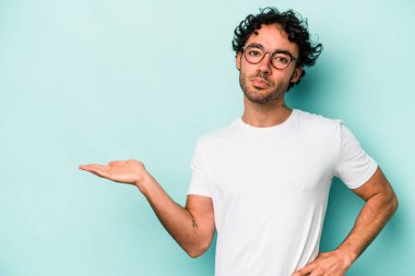 Beyaz arka planda izole edilmiş genç beyaz bir adam bir palmiye üzerinde fotokopi alanı gösteriyor ve belinde başka bir el tutuyor..