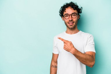 Beyaz arka planda izole edilmiş genç beyaz adam yan tarafı işaret ediyor