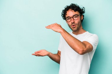 Beyaz arka planda izole edilmiş genç beyaz adam elleri arasında bir kopya alanı tutarken şok ve hayrete düştü..