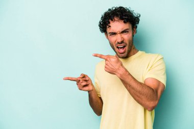 Beyaz arka planda izole edilmiş genç beyaz bir adam işaret parmağıyla fotokopi alanını işaret ederek heyecan ve arzusunu ifade ediyor..