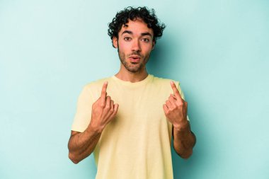 Beyaz arka planda izole edilmiş genç beyaz adam ağzı açık bir şekilde üst tarafı işaret ediyor..