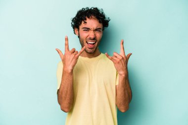 Beyaz arka planda izole edilmiş genç beyaz bir adam boynuzlarını devrim konsepti olarak gösteriyor..