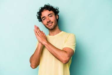 Beyaz arka planda izole olmuş genç beyaz bir adam enerjik ve rahat hissediyor, ellerini ovuşturuyor..