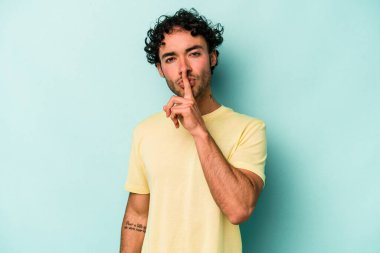 Beyaz arka planda izole edilmiş genç beyaz bir adam ya sır saklıyor ya da sessizlik istiyor..