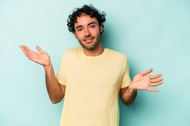 Beyaz arka planda izole edilmiş genç beyaz bir adam. Kafası karışmış ve omuz silkiyor. Kopya alanını tutmak için..