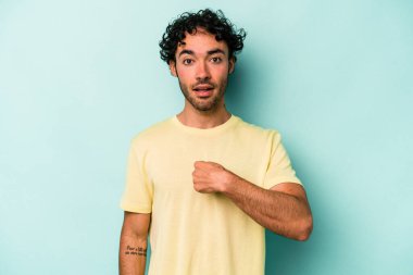 Beyaz arka planda izole edilmiş genç beyaz bir adam parmağını göstererek şaşırdı, geniş bir gülümsemeyle..