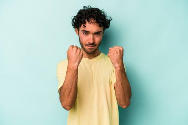 Beyaz arka planda izole edilmiş genç beyaz bir adam yumruğunu kameraya gösteriyor, agresif bir yüz ifadesi..