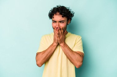 Beyaz arka planda izole olmuş genç beyaz bir adam bir şeye gülüyor, ağızlarını ellerle kapatıyor..