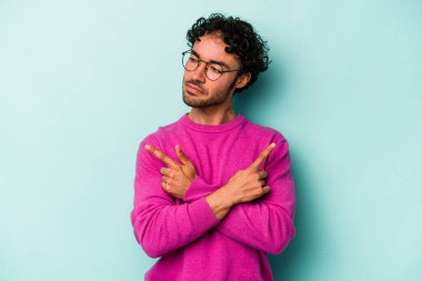 Beyaz arka plan noktalarında izole genç beyaz adam, iki seçenek arasında seçim yapmaya çalışıyor.