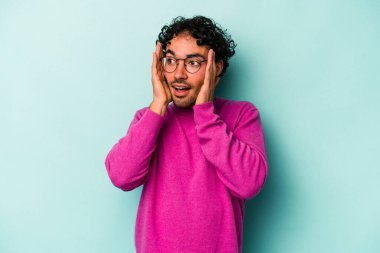 Beyaz arka planda izole edilmiş genç beyaz bir adam kulakları kulaklarıyla kapatıyor ve çok ses duymamaya çalışıyor..