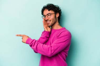 Beyaz arka planda izole edilmiş genç beyaz bir adam bir dedikodu söylüyor, bir haber sunuyor..