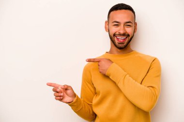 Beyaz arka planda izole edilmiş genç İspanyol adam işaret parmaklarıyla fotokopi alanını işaret ederek heyecan ve arzuyu ifade ediyor..