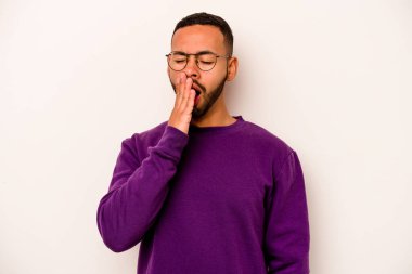 Beyaz arka planda izole edilmiş genç İspanyol adam esniyor. Ağzı eliyle kapatan yorgun bir hareket sergiliyor..