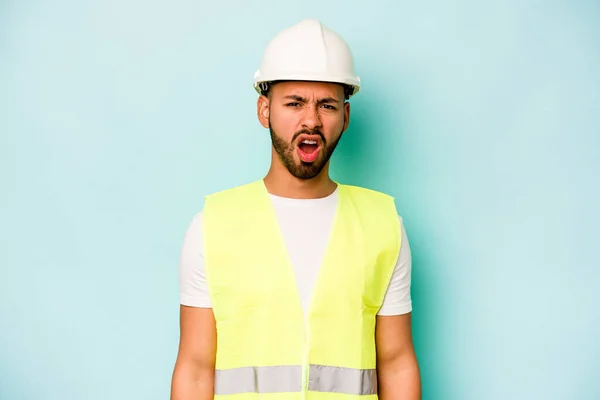 Young Laborer Hispanic Man Isolated Blue Background Screaming Very Angry — стоковое фото